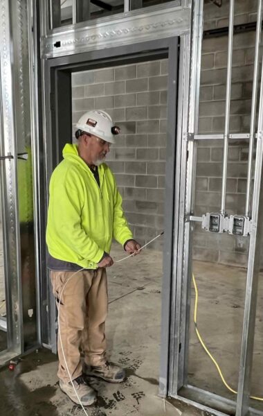 A contractor pulls wiring in a completed frame using Frame Frog at Franklin High School